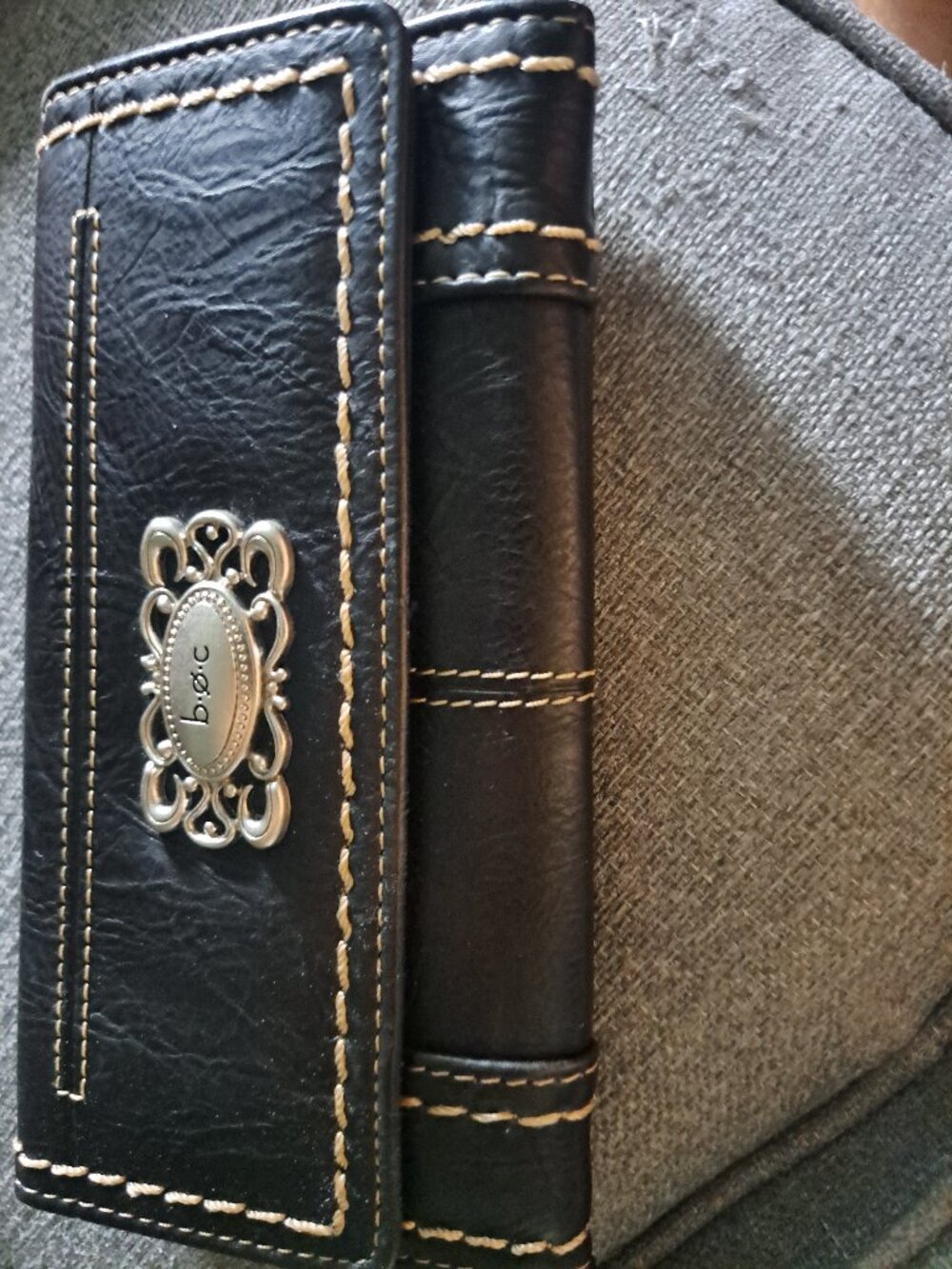 New Black leather b.ø.c. wallet has contrast cream stitching and silver-tone har